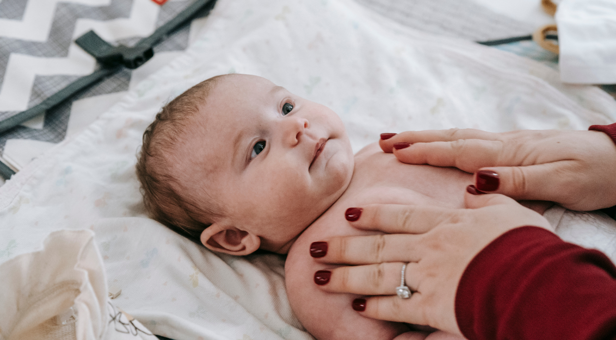 A person doing massage of a new born baby