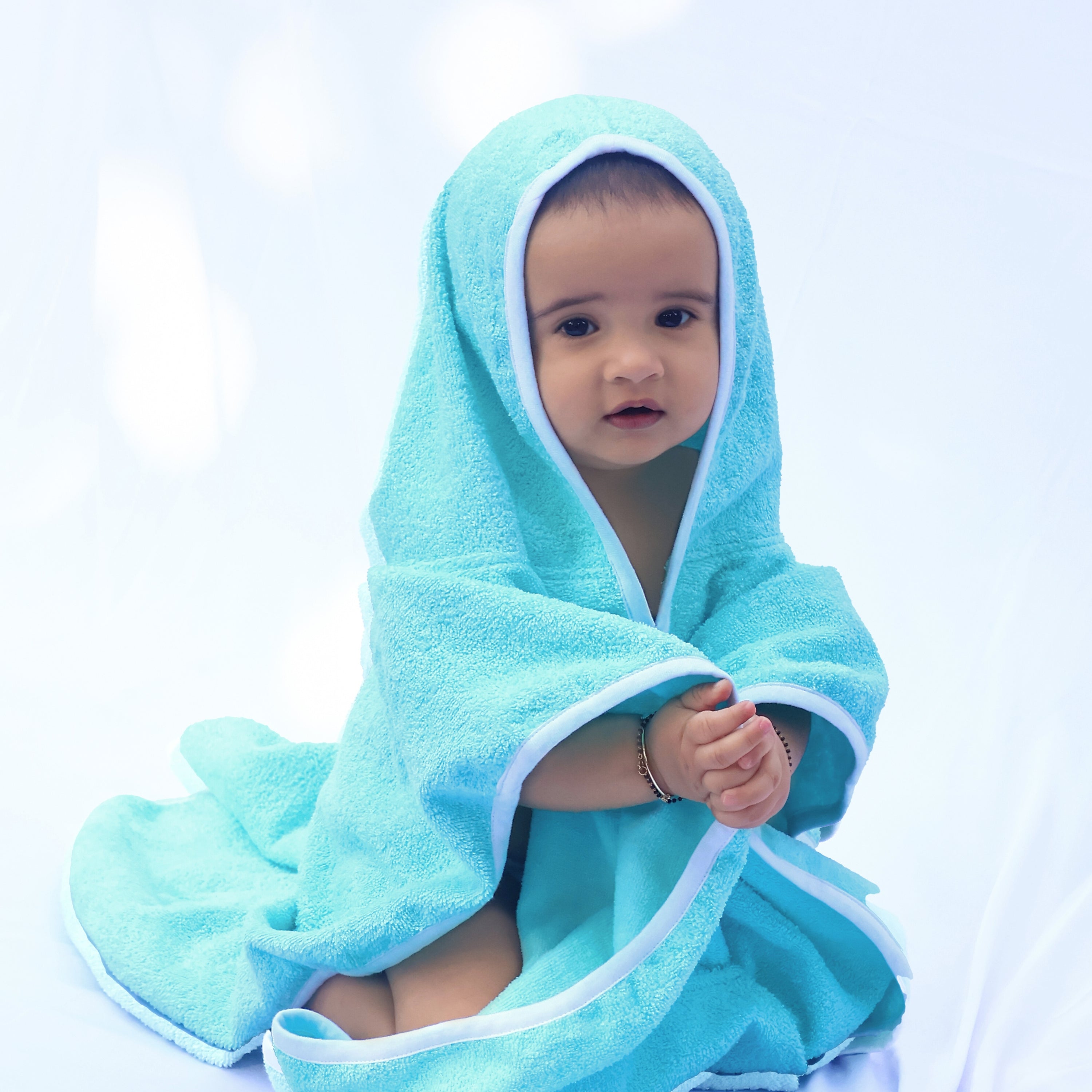 A baby wrapped in a blue bath towel 