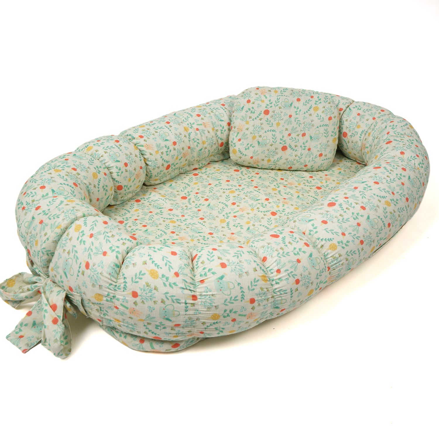 Baby nest bed with a soft cushion and a botanical floral print, featuring a tied bow.