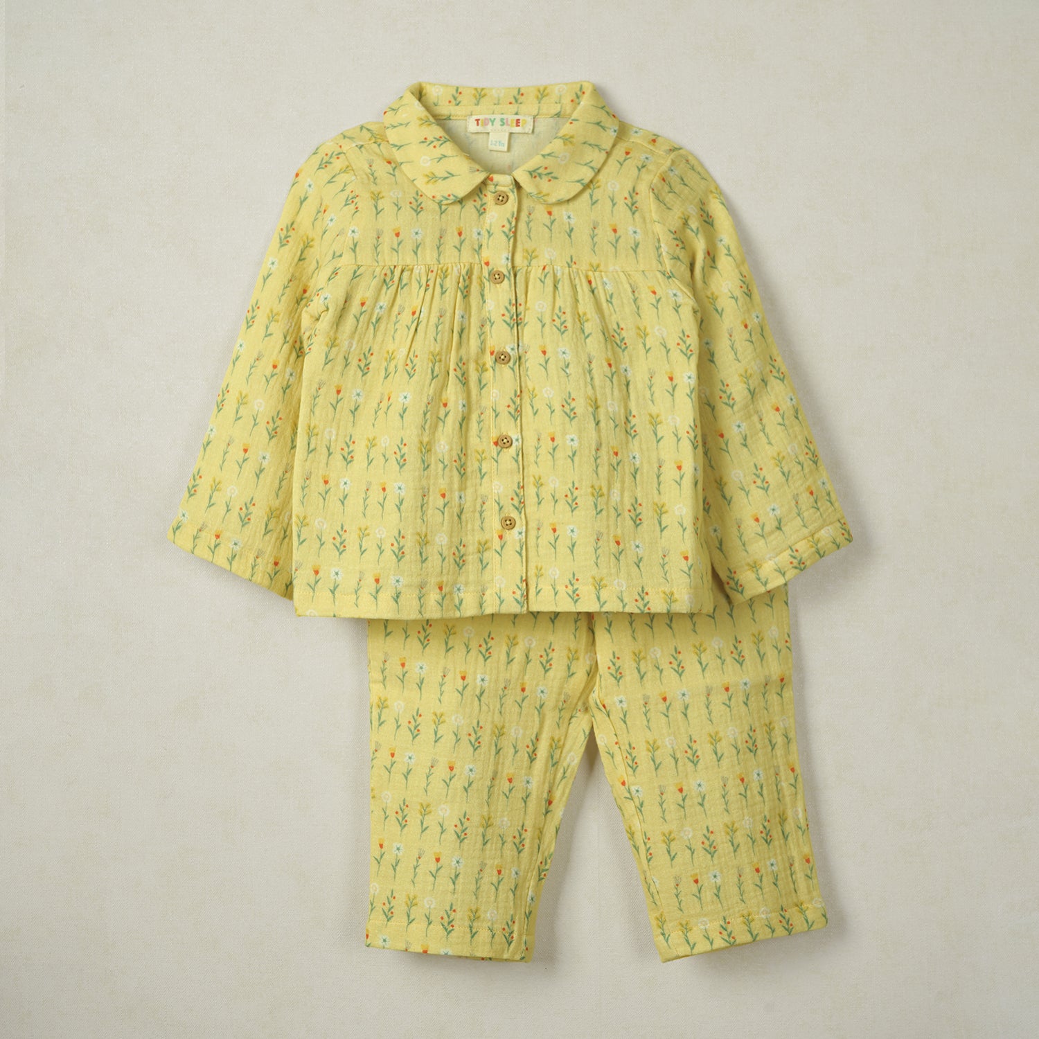 Yellow baby pajama set with a delicate floral print, featuring a button-up top with a Peter Pan collar and matching pants.