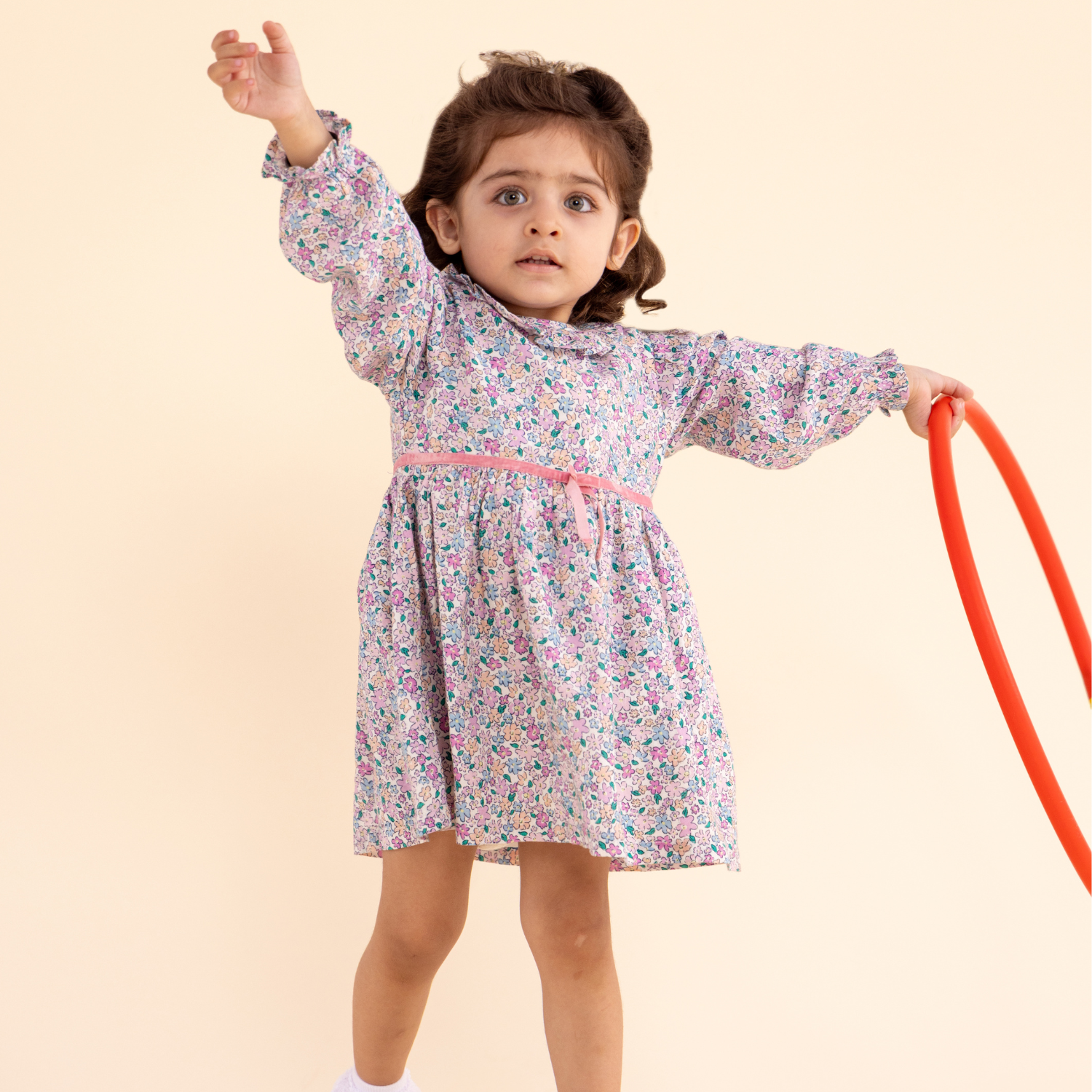 A Baby girl is dressed in a ditsy floral frock dress